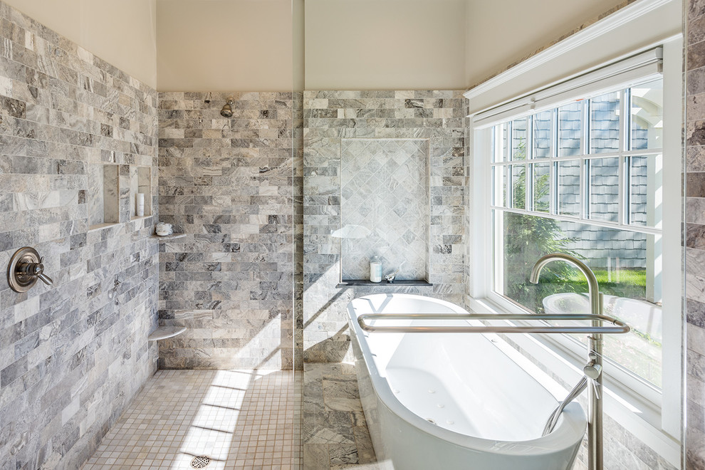 Design ideas for a large classic ensuite bathroom in Minneapolis with flat-panel cabinets, white cabinets, a freestanding bath, a walk-in shower, multi-coloured tiles, stone tiles, beige walls, porcelain flooring, a submerged sink and solid surface worktops.