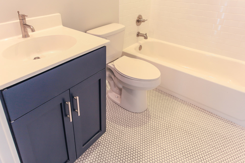Стильный дизайн: детская ванная комната среднего размера в морском стиле с фасадами в стиле шейкер, синими фасадами, ванной в нише, унитазом-моноблоком, белой плиткой, серыми стенами, полом из мозаичной плитки, столешницей из искусственного кварца и белым полом - последний тренд