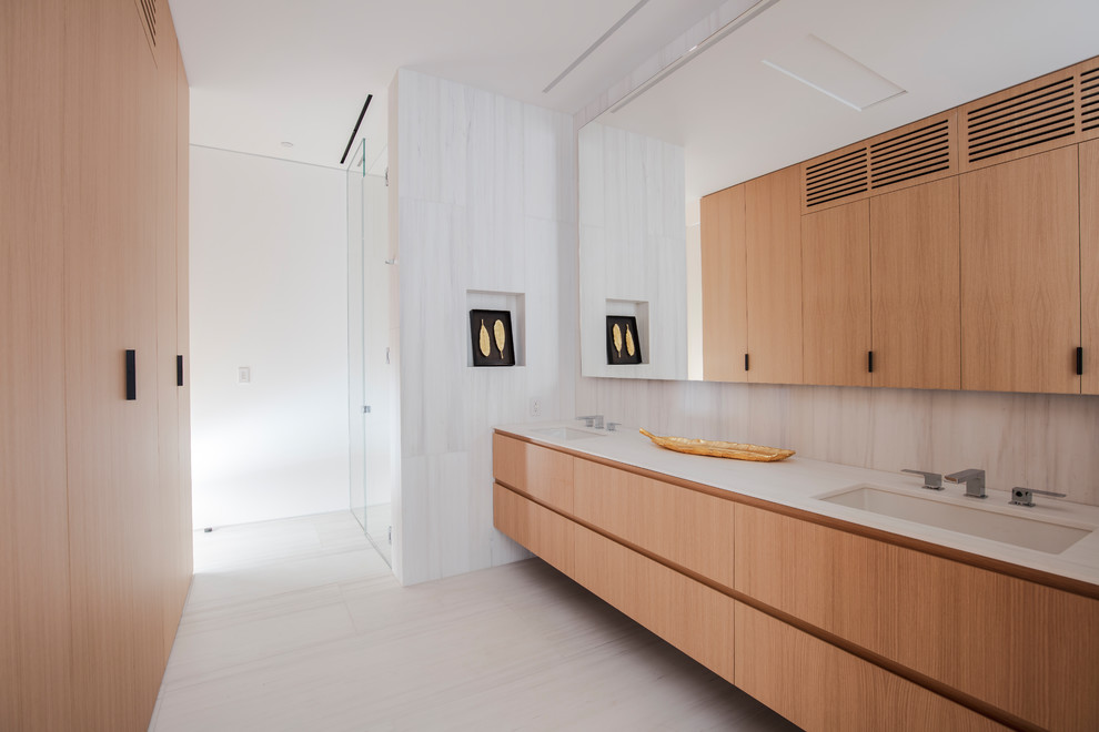 Geräumiges Modernes Badezimmer En Suite mit flächenbündigen Schrankfronten, hellen Holzschränken, Unterbauwaschbecken, beigem Boden und weißer Waschtischplatte in Los Angeles