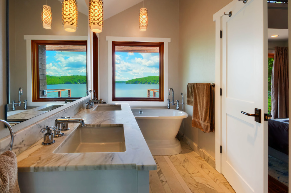 Imagen de cuarto de baño de estilo americano con lavabo bajoencimera, bañera exenta, ducha empotrada y suelo de mármol