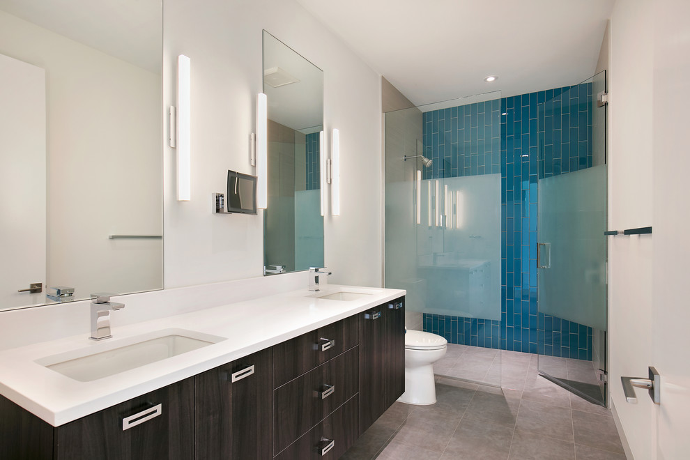 Example of a large minimalist 3/4 blue tile and glass tile porcelain tile and gray floor walk-in shower design in Tampa with flat-panel cabinets, brown cabinets, a two-piece toilet, white walls, an undermount sink, quartz countertops, a hinged shower door and white countertops