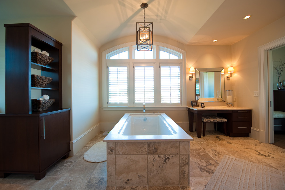Inredning av ett klassiskt stort en-suite badrum, med släta luckor, skåp i mörkt trä, ett fristående badkar, beige kakel, stenkakel, beige väggar, marmorgolv och marmorbänkskiva