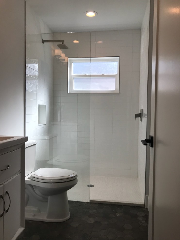 На фото: ванная комната среднего размера в стиле ретро с белыми фасадами, душем в нише, раздельным унитазом, белой плиткой, керамогранитной плиткой, белыми стенами, полом из сланца, душевой кабиной, монолитной раковиной, серым полом и открытым душем