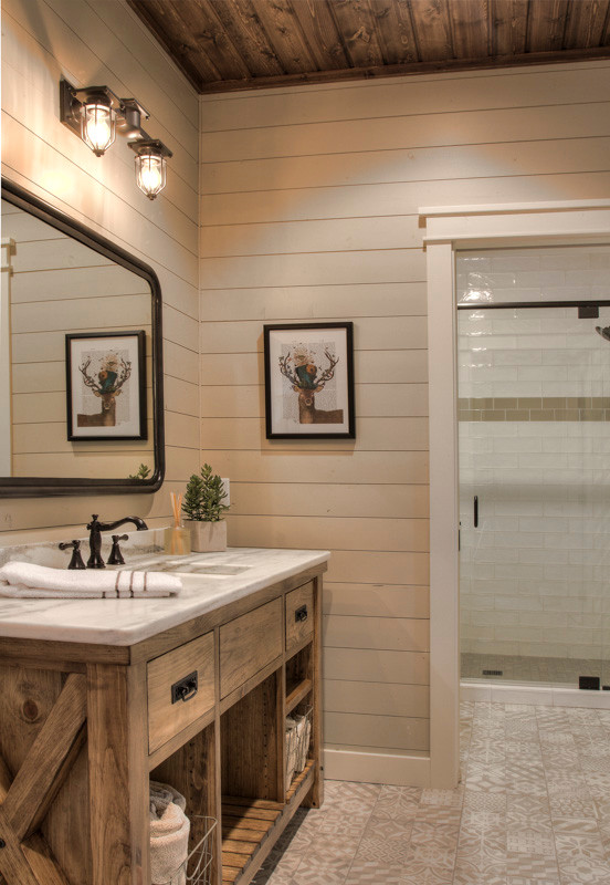 Lantlig inredning av ett mellanstort vit vitt badrum med dusch, med öppna hyllor, skåp i mellenmörkt trä, vit kakel, glaskakel, vita väggar, klinkergolv i keramik, ett undermonterad handfat, marmorbänkskiva, flerfärgat golv och dusch med gångjärnsdörr