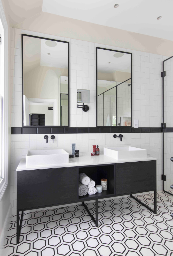 Modern inredning av ett mellanstort vit vitt en-suite badrum, med släta luckor, svarta skåp, en öppen dusch, vit kakel, tunnelbanekakel, granitbänkskiva, dusch med gångjärnsdörr, grå väggar, ett fristående handfat och flerfärgat golv