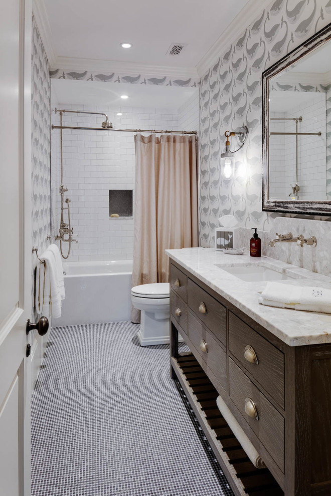 Aménagement d'une salle d'eau bord de mer en bois foncé avec une baignoire en alcôve, un combiné douche/baignoire, un carrelage blanc, un carrelage métro, un mur gris, un lavabo encastré, un sol gris, une cabine de douche avec un rideau et un plan de toilette gris.