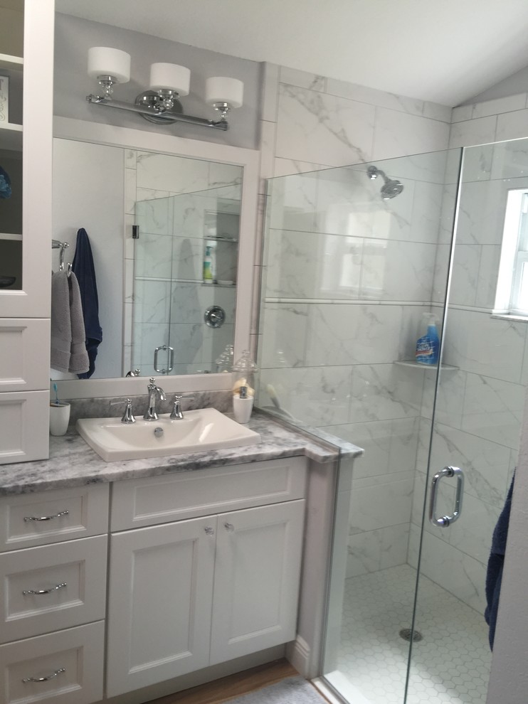 Immagine di una stanza da bagno padronale classica di medie dimensioni con ante con riquadro incassato, ante bianche, doccia alcova, pareti grigie, parquet chiaro, lavabo a bacinella e top in marmo