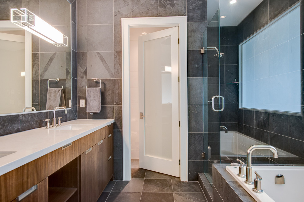 This is an example of a traditional bathroom in Vancouver with flat-panel cabinets, dark wood cabinets, a corner shower and grey tiles.