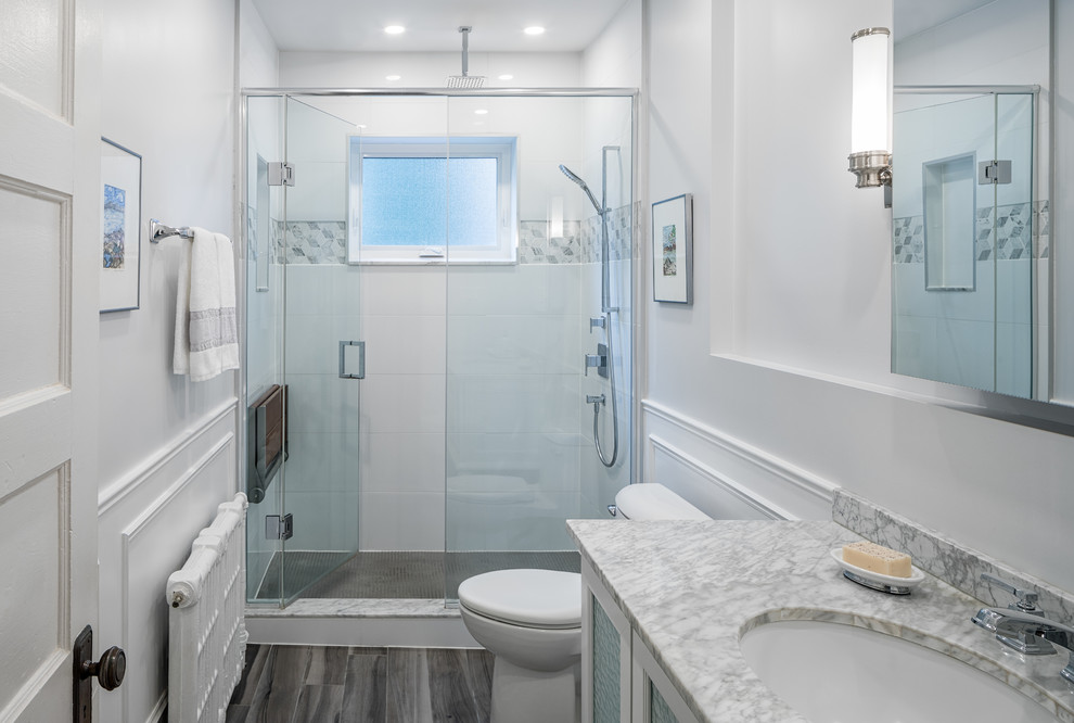Inredning av ett klassiskt mellanstort badrum med dusch, med luckor med glaspanel, vita skåp, en dusch i en alkov, grå kakel, vit kakel, marmorkakel, vita väggar, ett undermonterad handfat, marmorbänkskiva, grått golv och dusch med gångjärnsdörr