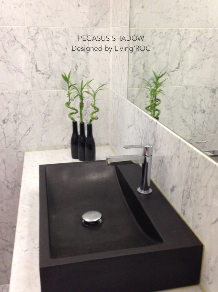 Immagine di una stanza da bagno padronale design con lavabo a bacinella, ante in legno chiaro e top in granito