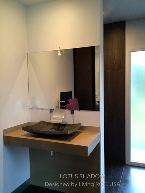 Immagine di una stanza da bagno padronale minimal con lavabo a bacinella, ante in legno chiaro e top in granito