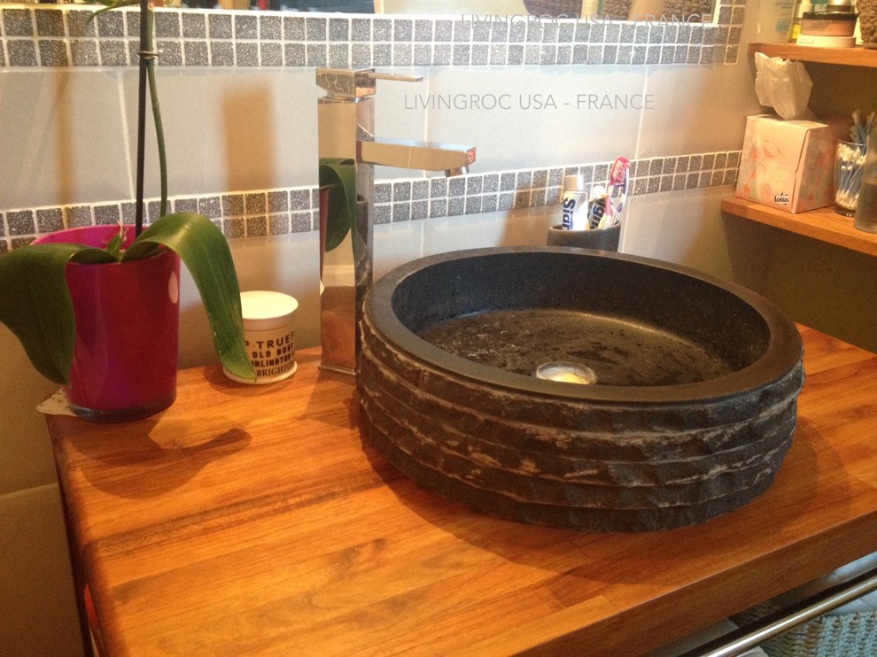 Esempio di una stanza da bagno padronale contemporanea con lavabo a bacinella, ante in legno chiaro e top in granito
