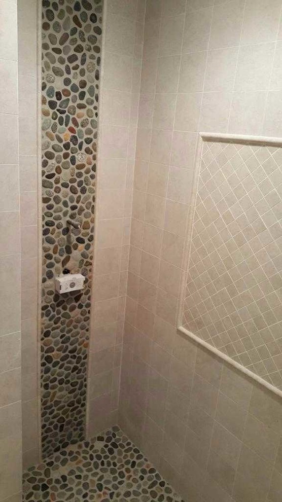 Kleines Klassisches Duschbad mit Duschnische, beigen Fliesen, Keramikfliesen, Kiesel-Bodenfliesen, braunem Boden und Falttür-Duschabtrennung in New York