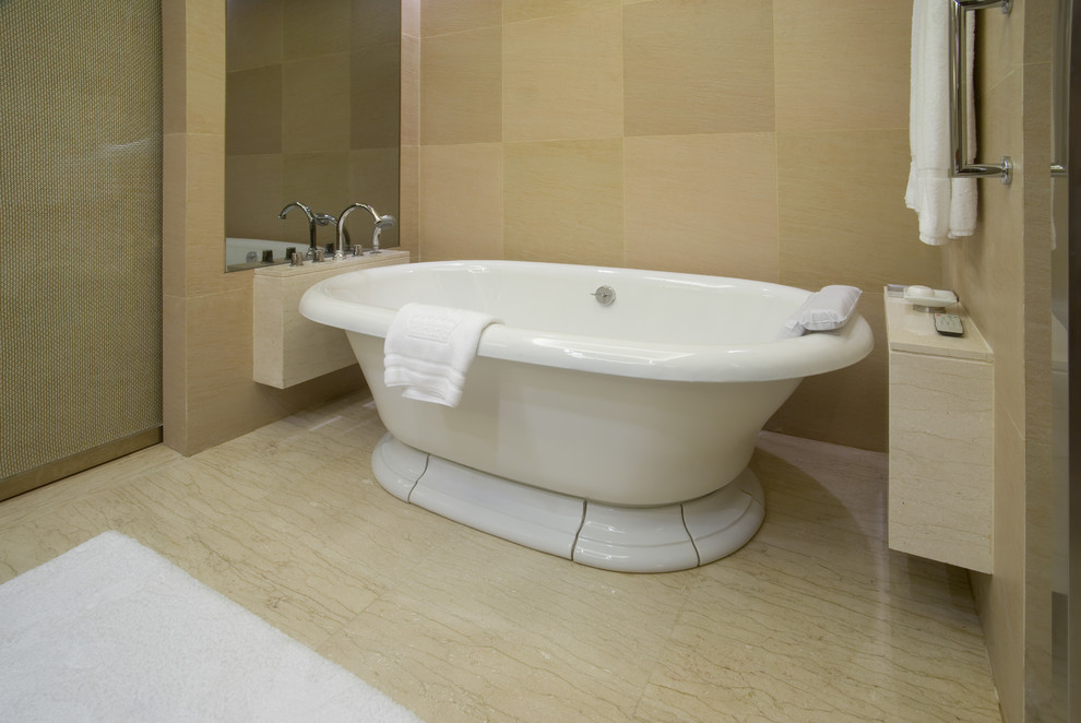 Пример оригинального дизайна: главная ванная комната среднего размера в стиле модернизм с плоскими фасадами, светлыми деревянными фасадами, накладной ванной, керамогранитной плиткой, бежевыми стенами, полом из керамогранита, столешницей из известняка и бежевым полом