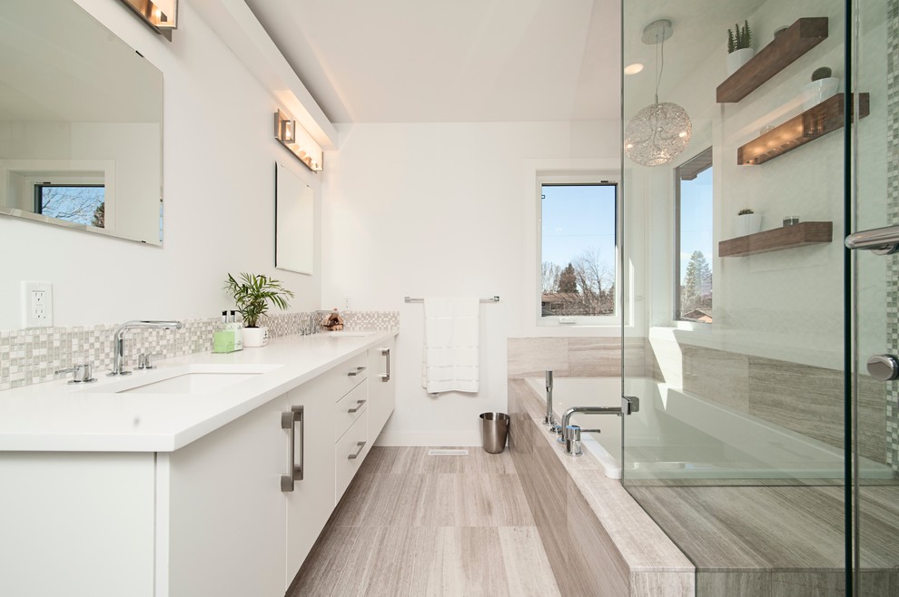 Свежая идея для дизайна: большая главная ванная комната в стиле неоклассика (современная классика) с плоскими фасадами, белыми фасадами, японской ванной, душем над ванной, унитазом-моноблоком, белой плиткой, керамической плиткой, белыми стенами, полом из керамической плитки, подвесной раковиной, столешницей из гранита, серым полом и белой столешницей - отличное фото интерьера