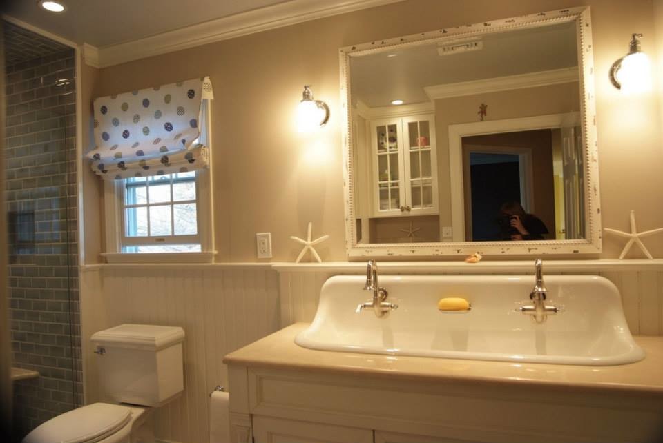 Exemple d'une salle de bain bord de mer en bois vieilli de taille moyenne avec un lavabo suspendu, un placard à porte affleurante, un plan de toilette en marbre, un carrelage bleu, des carreaux de porcelaine et un mur beige.