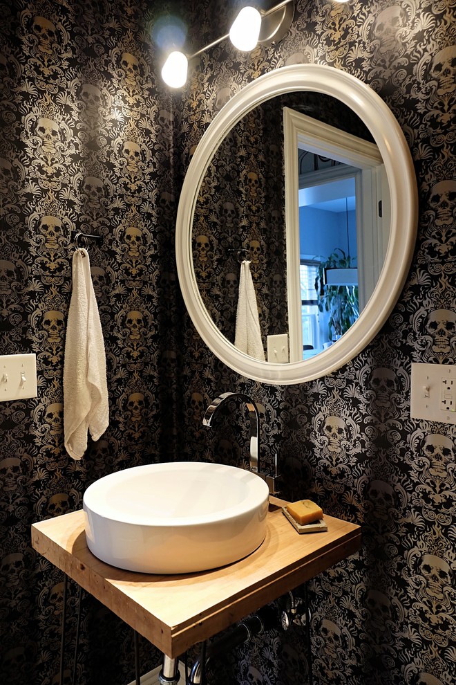 Esempio di una piccola stanza da bagno con doccia boho chic con ante lisce, ante blu, WC a due pezzi, pareti nere, pavimento con piastrelle in ceramica, lavabo a bacinella, top in legno e pavimento bianco