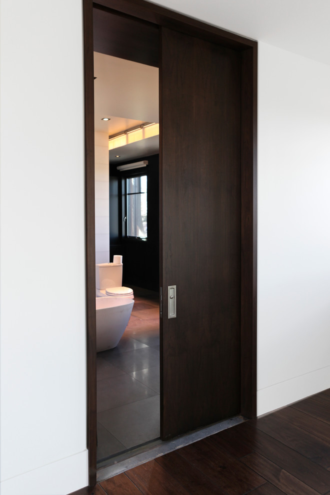 Mittelgroßes Modernes Badezimmer En Suite mit flächenbündigen Schrankfronten, Doppeldusche, Toilette mit Aufsatzspülkasten, grauen Fliesen, weißer Wandfarbe und dunklem Holzboden in Denver