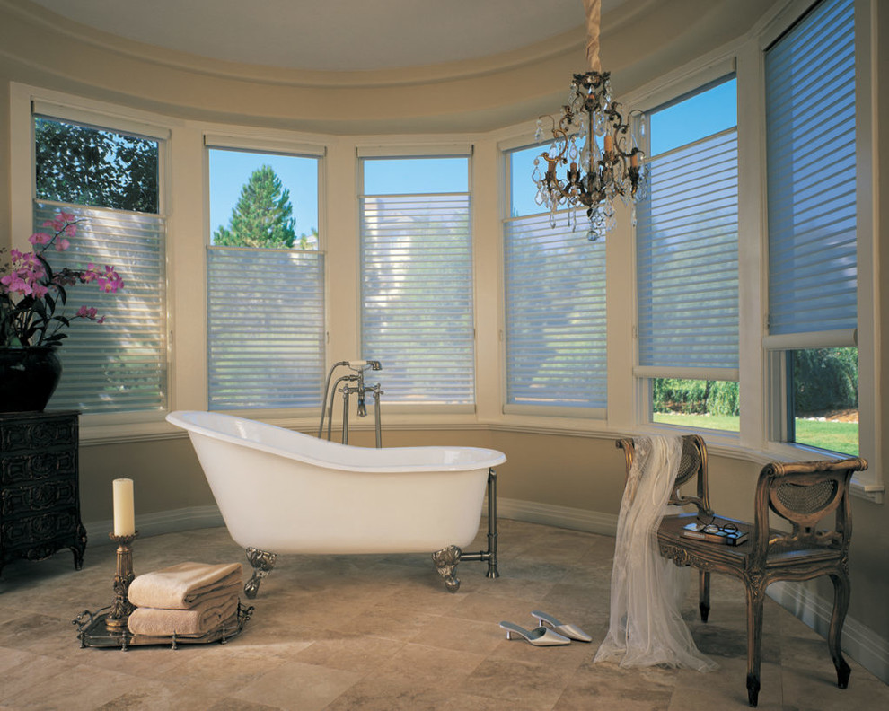 На фото: главная ванная комната среднего размера в викторианском стиле с отдельно стоящей ванной, бежевыми стенами, полом из керамогранита и бежевым полом с