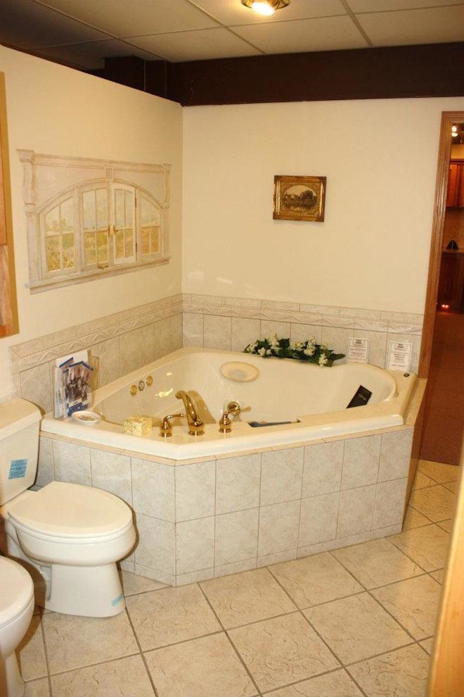 Idee per una stanza da bagno padronale di medie dimensioni con vasca idromassaggio, WC monopezzo, pareti bianche e pavimento con piastrelle in ceramica