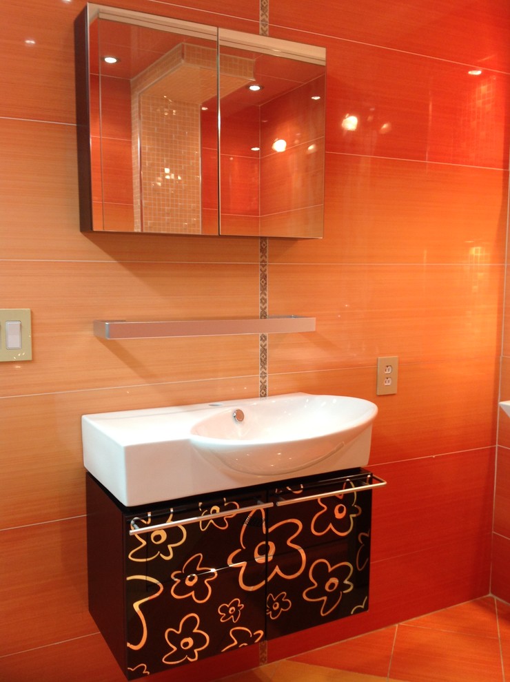 Immagine di una stanza da bagno moderna con lavabo sospeso, ante lisce, ante nere, piastrelle arancioni e piastrelle in ceramica