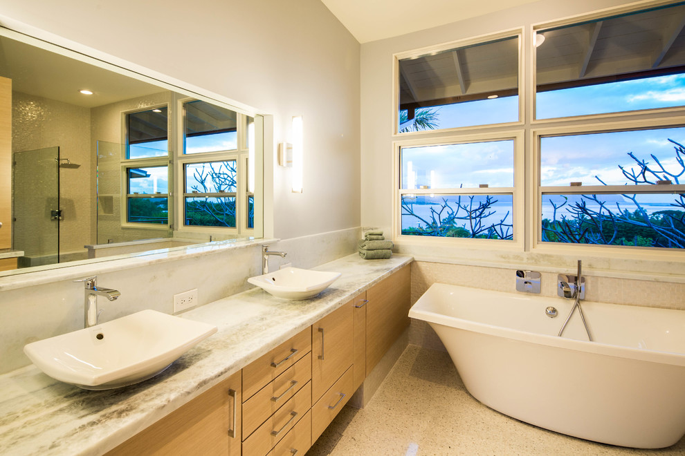 Modernes Badezimmer mit flächenbündigen Schrankfronten, hellen Holzschränken, Granit-Waschbecken/Waschtisch, freistehender Badewanne, Eckdusche, farbigen Fliesen und grauer Wandfarbe in Hawaii