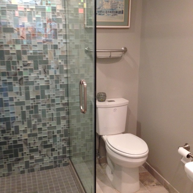 Идея дизайна: ванная комната среднего размера в современном стиле с угловым душем, раздельным унитазом, серой плиткой, разноцветной плиткой, белой плиткой, стеклянной плиткой, серыми стенами, полом из керамической плитки, душевой кабиной, бежевым полом и душем с распашными дверями