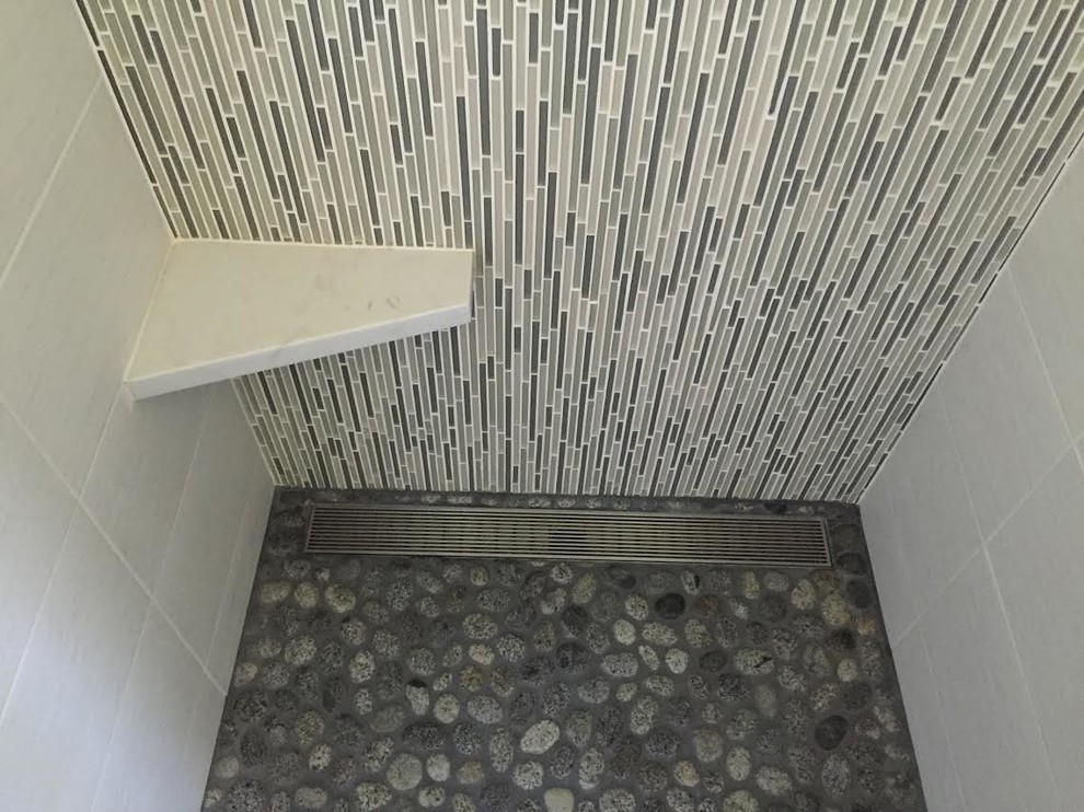 Inredning av ett modernt mellanstort en-suite badrum, med släta luckor, skåp i mörkt trä, ett hörnbadkar, en öppen dusch, cementkakel, vita väggar, ett avlångt handfat och bänkskiva i kvartsit