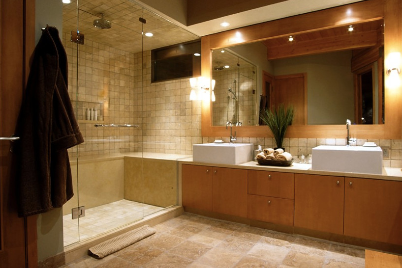 Cette image montre une grande douche en alcôve principale design en bois brun avec un placard à porte plane, un carrelage de pierre, un mur beige, un sol en carrelage de porcelaine, une vasque, un sol beige, une cabine de douche à porte battante, un carrelage beige, un plan de toilette en quartz et un plan de toilette beige.