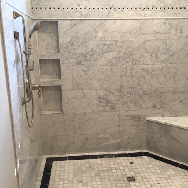 Cette photo montre une douche en alcôve principale chic de taille moyenne avec un carrelage blanc, du carrelage en marbre, un mur blanc, un sol en carrelage de céramique, un sol blanc et aucune cabine.