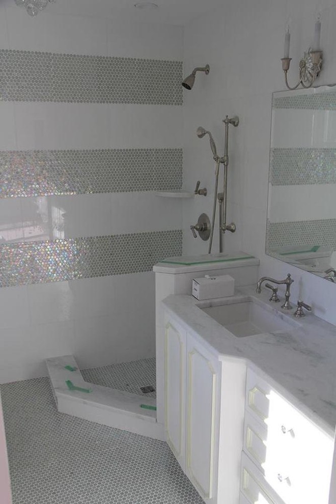 This is an example of a medium sized classic bathroom in New York with recessed-panel cabinets, white cabinets, a corner shower, grey tiles, mosaic tiles, white walls, mosaic tile flooring, a submerged sink, marble worktops and grey floors.