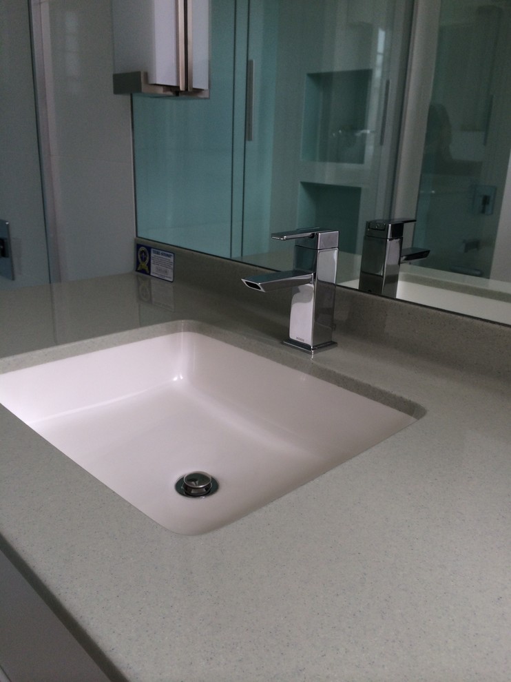 Example of a mid-sized trendy 3/4 white tile porcelain tile and gray floor bathroom design in Orange County with flat-panel cabinets, white cabinets, a one-piece toilet, white walls, an undermount sink and quartz countertops