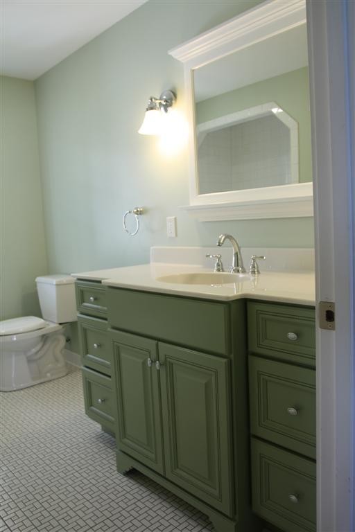 Esempio di una stanza da bagno con doccia minimal di medie dimensioni con ante con bugna sagomata, ante verdi, WC a due pezzi, pareti verdi, pavimento con piastrelle a mosaico, lavabo integrato, top in superficie solida e pavimento bianco