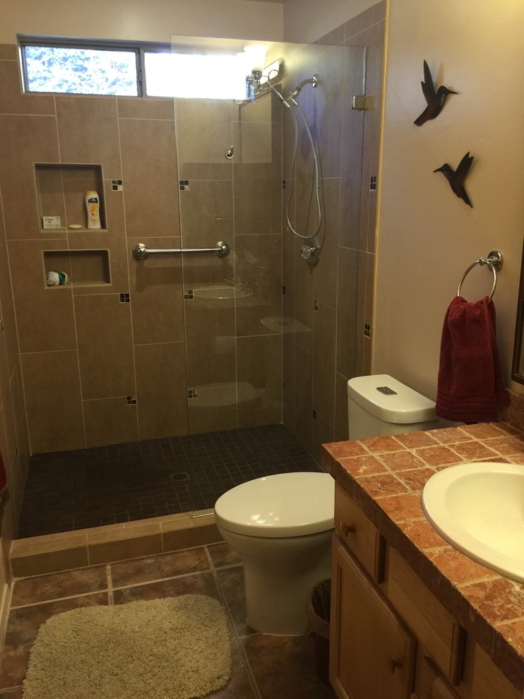 Cette photo montre une salle de bain chic en bois clair de taille moyenne avec un placard à porte shaker, WC séparés, un carrelage beige, un mur beige, un sol en carrelage de céramique, un lavabo posé et un plan de toilette en carrelage.