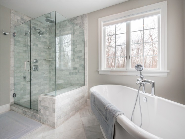 Foto di una grande stanza da bagno padronale tradizionale con piastrelle grigie, vasca freestanding, doccia ad angolo, piastrelle di vetro, pareti grigie e pavimento in gres porcellanato