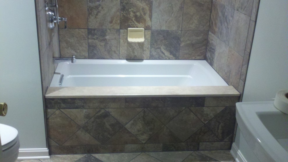 Exempel på ett klassiskt badrum, med ett badkar i en alkov, en dusch/badkar-kombination, brun kakel och porslinskakel