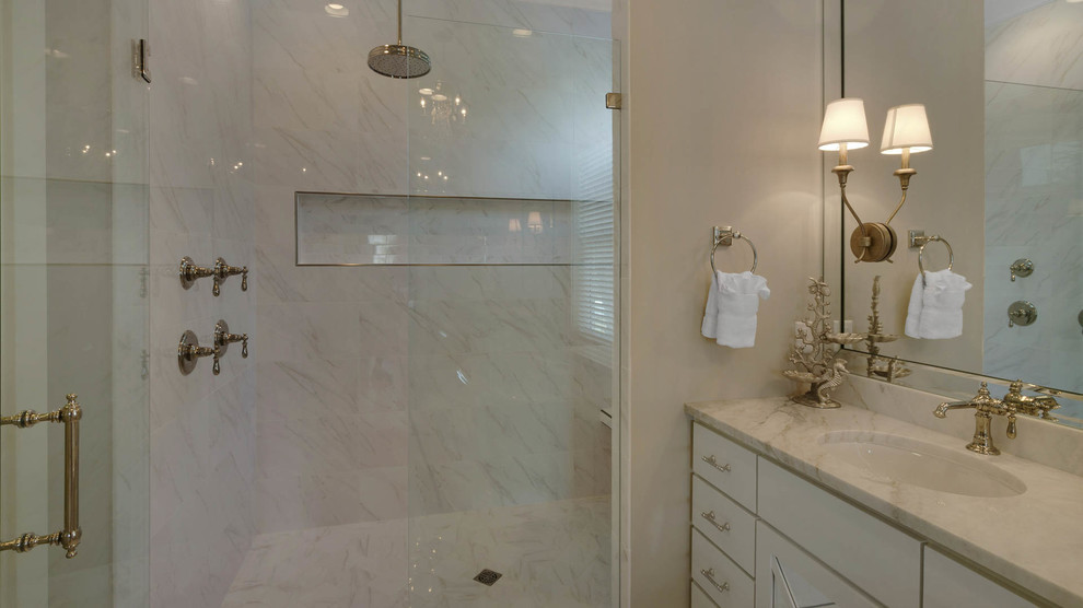 Inspiration for a large beach style ensuite bathroom in Miami with flat-panel cabinets, white cabinets, a freestanding bath, an alcove shower, white tiles, stone slabs, beige walls, porcelain flooring, a submerged sink and marble worktops.