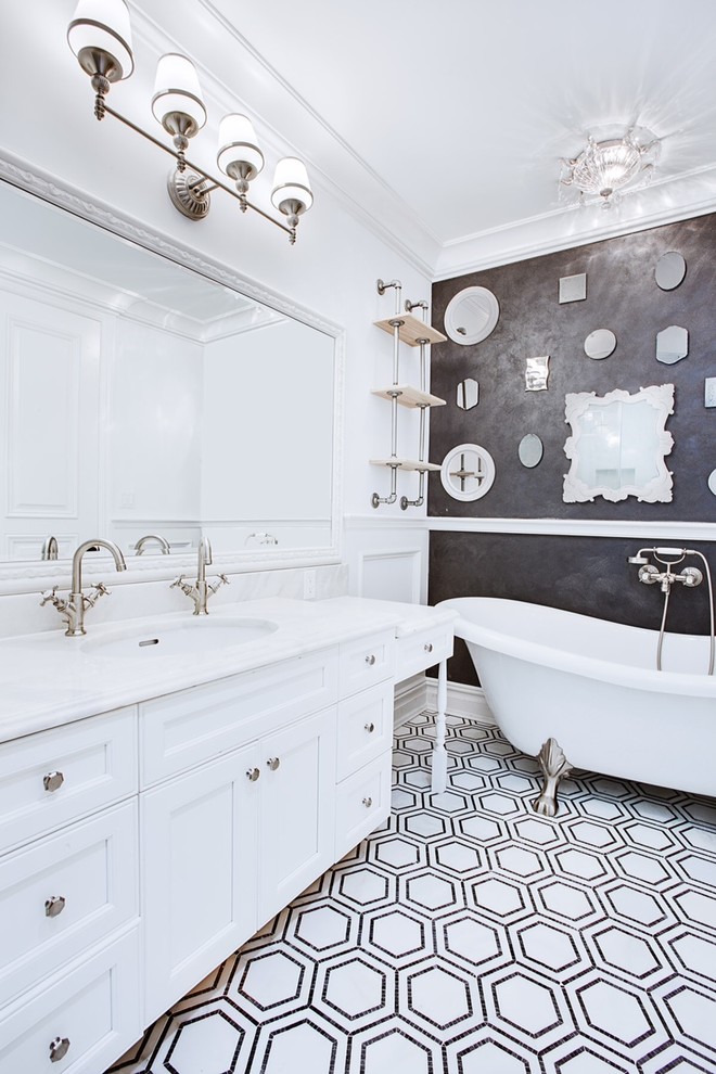 Diseño de cuarto de baño clásico con lavabo bajoencimera, armarios con paneles empotrados, puertas de armario blancas, bañera con patas y paredes grises
