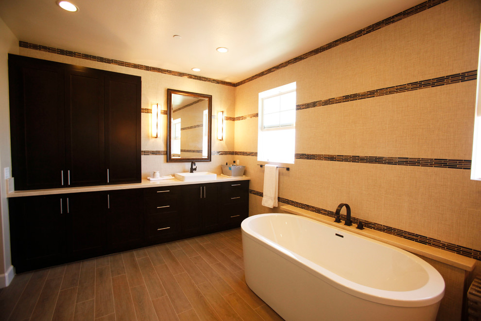 Inspiration for a large contemporary master dark wood floor freestanding bathtub remodel in Los Angeles with recessed-panel cabinets, dark wood cabinets, brown walls and a drop-in sink