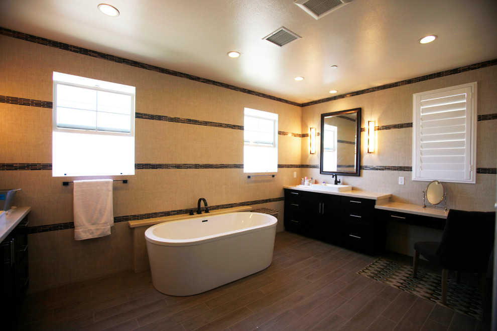 Example of a large trendy master dark wood floor freestanding bathtub design in Los Angeles with recessed-panel cabinets, dark wood cabinets, brown walls and a drop-in sink