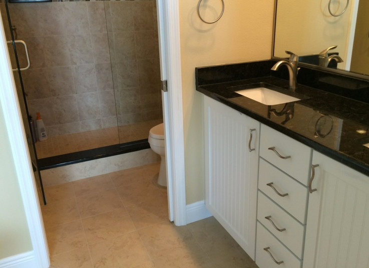 Modelo de cuarto de baño infantil de tamaño medio con lavabo encastrado, puertas de armario blancas, encimera de zinc, ducha empotrada, paredes beige y suelo de baldosas de cerámica