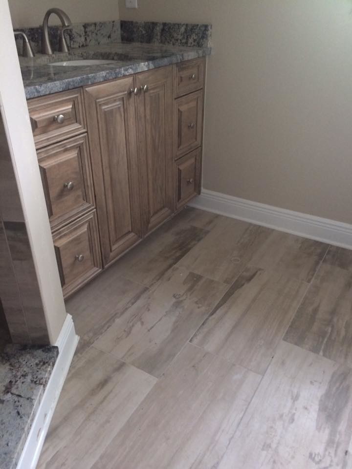 Mid-sized trendy 3/4 beige tile and limestone tile porcelain tile and beige floor bathroom photo in Tampa with raised-panel cabinets, medium tone wood cabinets, beige walls, an undermount sink and granite countertops