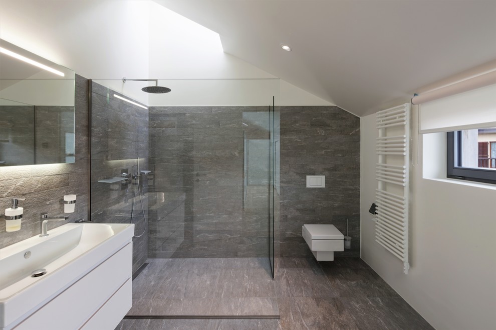 Exempel på ett mellanstort modernt badrum, med släta luckor, vita skåp, en öppen dusch, en vägghängd toalettstol, grå kakel, stenkakel, beige väggar, klinkergolv i porslin, ett integrerad handfat, brunt golv och med dusch som är öppen