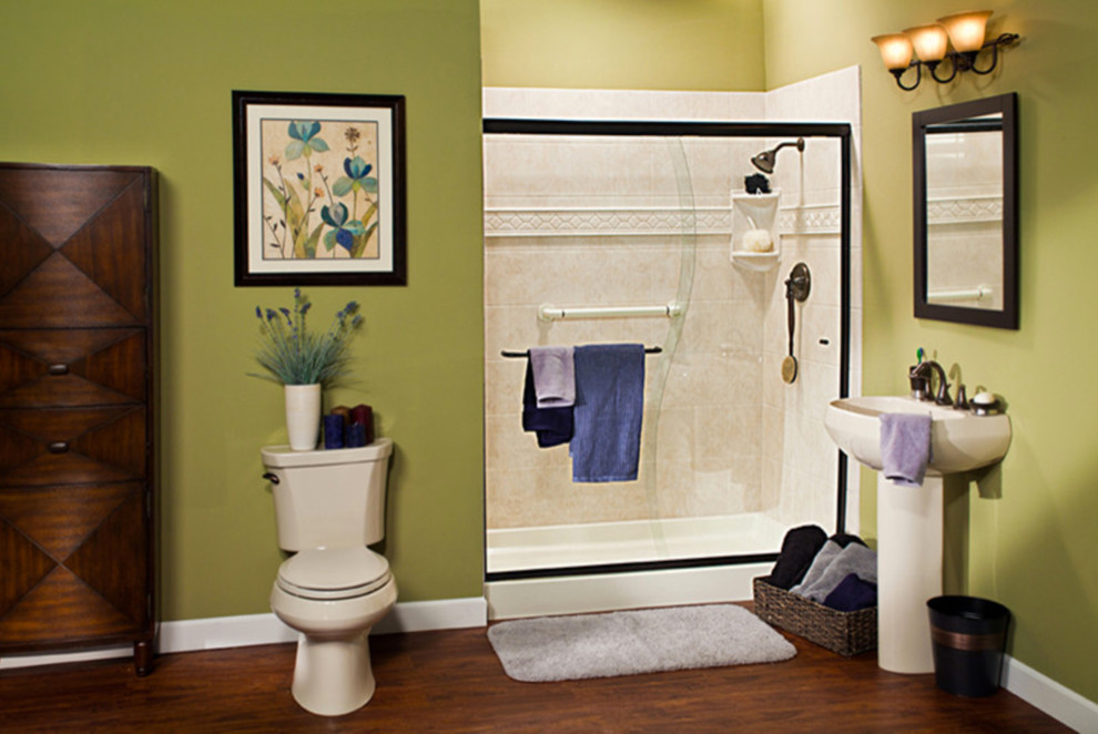 This is an example of a medium sized traditional bathroom in Albuquerque with an alcove shower, a two-piece toilet, green walls, dark hardwood flooring, a pedestal sink, brown floors and a sliding door.