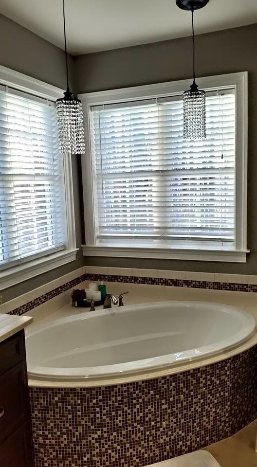 На фото: главная ванная комната среднего размера в стиле фьюжн с фасадами с утопленной филенкой, черными фасадами, угловой ванной, унитазом-моноблоком, бежевой плиткой, черной плиткой, разноцветной плиткой, плиткой мозаикой, серыми стенами, полом из известняка, врезной раковиной, столешницей из известняка и бежевым полом