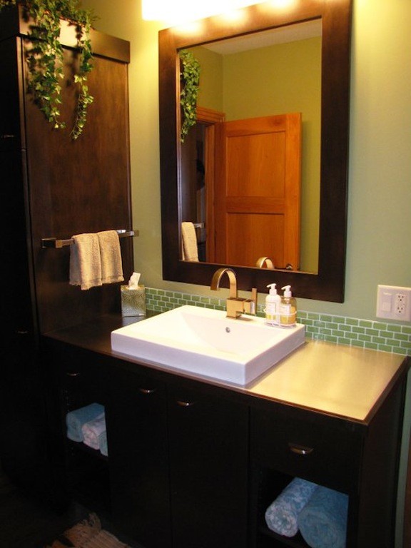 Immagine di una stanza da bagno con doccia design di medie dimensioni con ante in legno bruno, piastrelle verdi, piastrelle di vetro, pareti verdi e lavabo da incasso