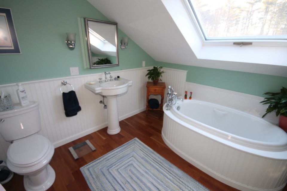 Inspiration for a large classic ensuite bathroom in Portland Maine with white cabinets, white tiles, ceramic tiles, green walls and dark hardwood flooring.