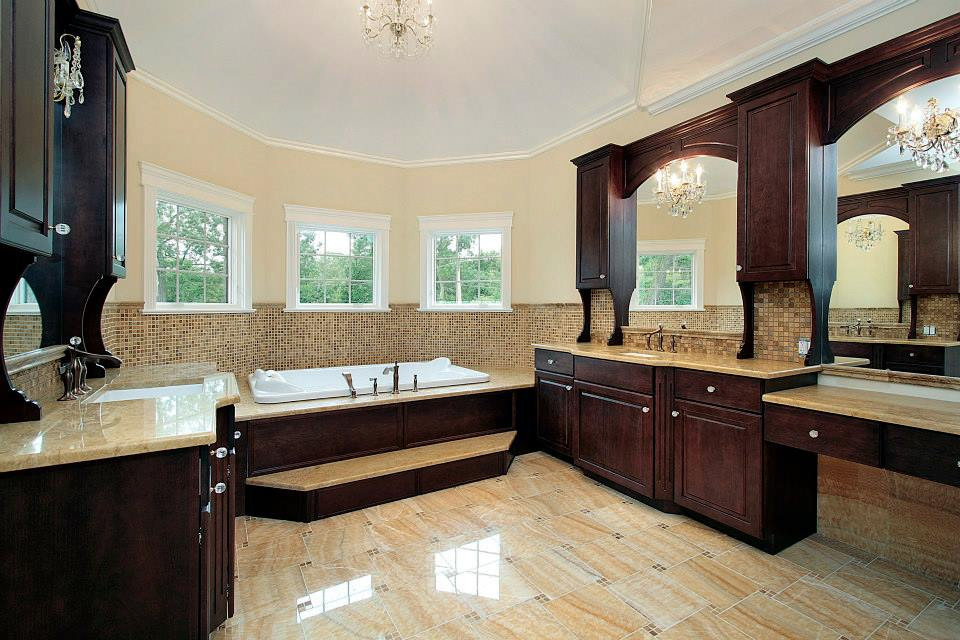 Large classic ensuite bathroom in Los Angeles with raised-panel cabinets, dark wood cabinets, a built-in bath, beige tiles, brown tiles, mosaic tiles, beige walls, porcelain flooring, a submerged sink, engineered stone worktops and beige floors.