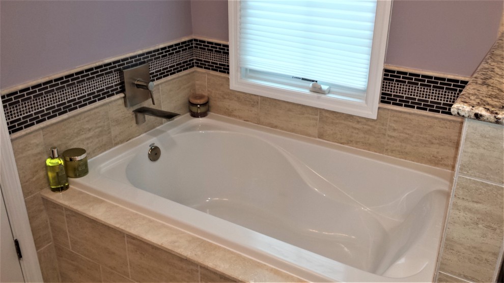 Example of a mid-sized classic master beige tile and porcelain tile laminate floor and beige floor bathroom design in Philadelphia with raised-panel cabinets, dark wood cabinets, a one-piece toilet, purple walls, an undermount sink, granite countertops, a hinged shower door and beige countertops