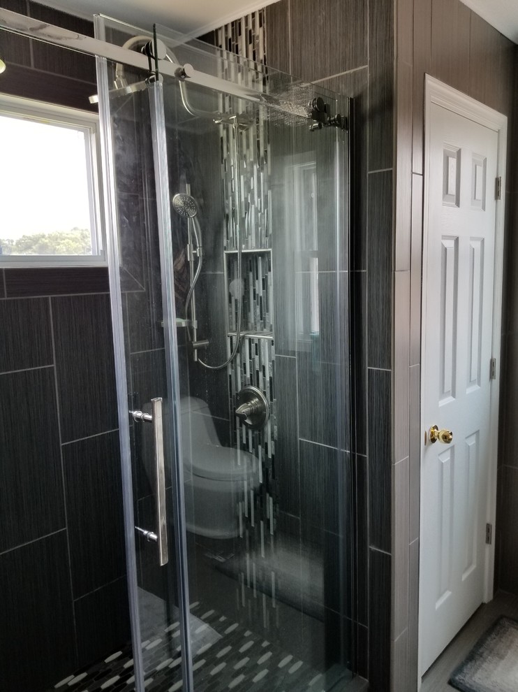 Inredning av ett modernt mellanstort badrum med dusch, med en dusch i en alkov, svart och vit kakel, grå kakel, stickkakel, bruna väggar, laminatgolv, beiget golv och dusch med skjutdörr